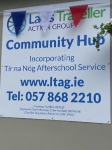 A sign posted on a wall that reads "Community Hub: Incorporating Tír na Nog Afterschool Service. www.ltag.ie, 057 868 2210.